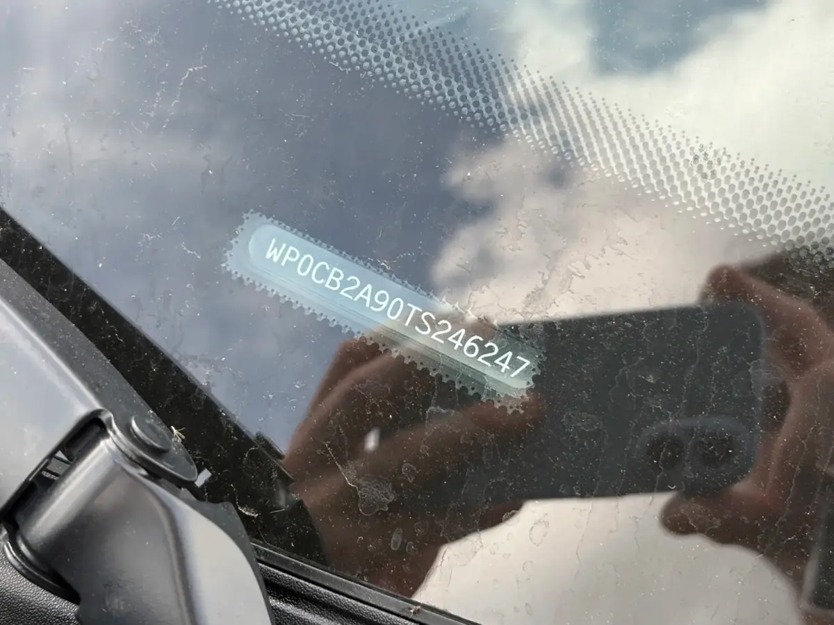 VIN plate of the same Porsche 911 photographed through the windshield